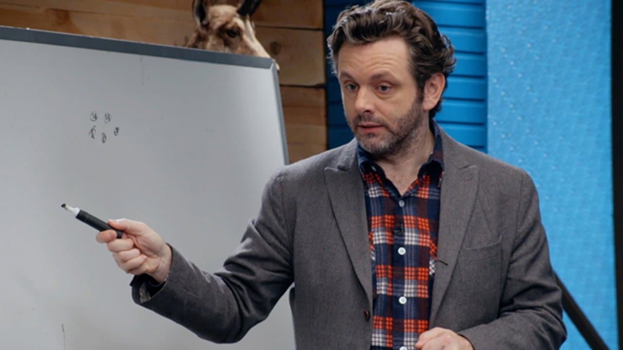 Still from Michael Sheen Wears a Plaid Button Down and Grey Blazer