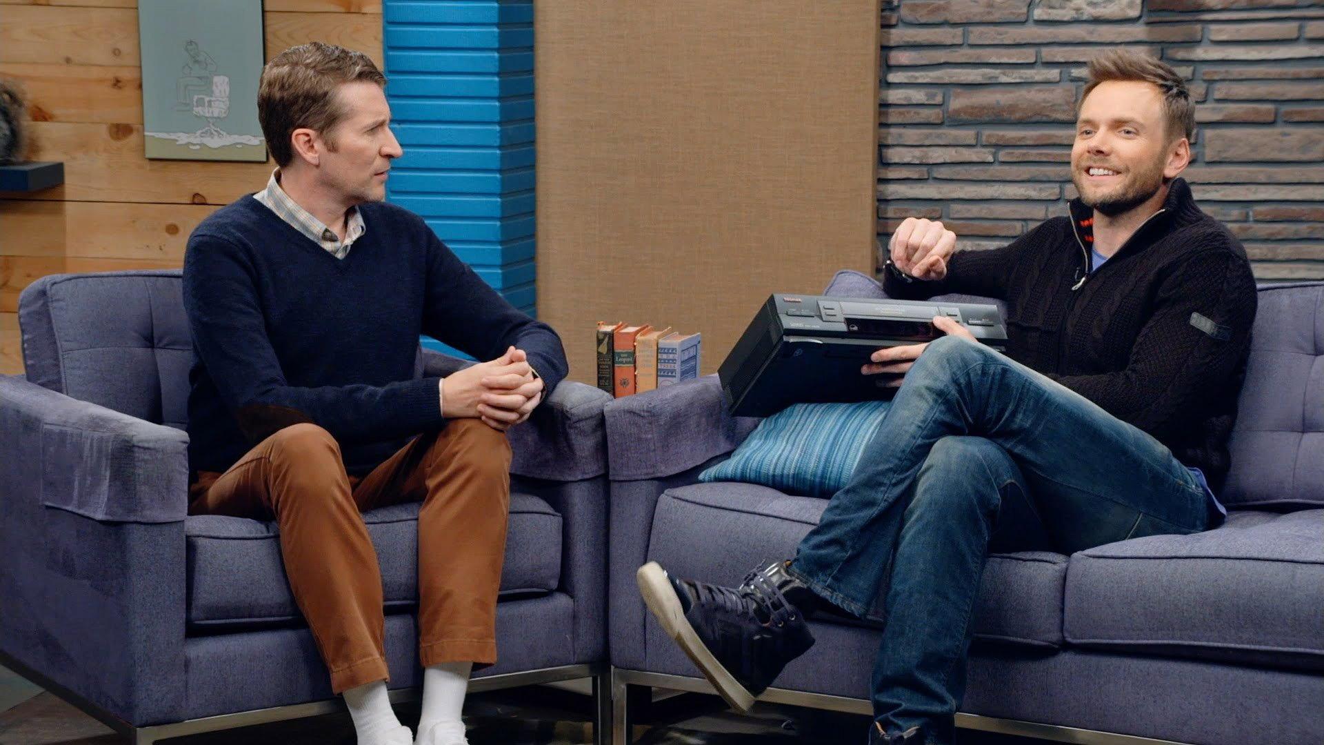 Still from Joel McHale Wears a Navy Zip-up and High Tops